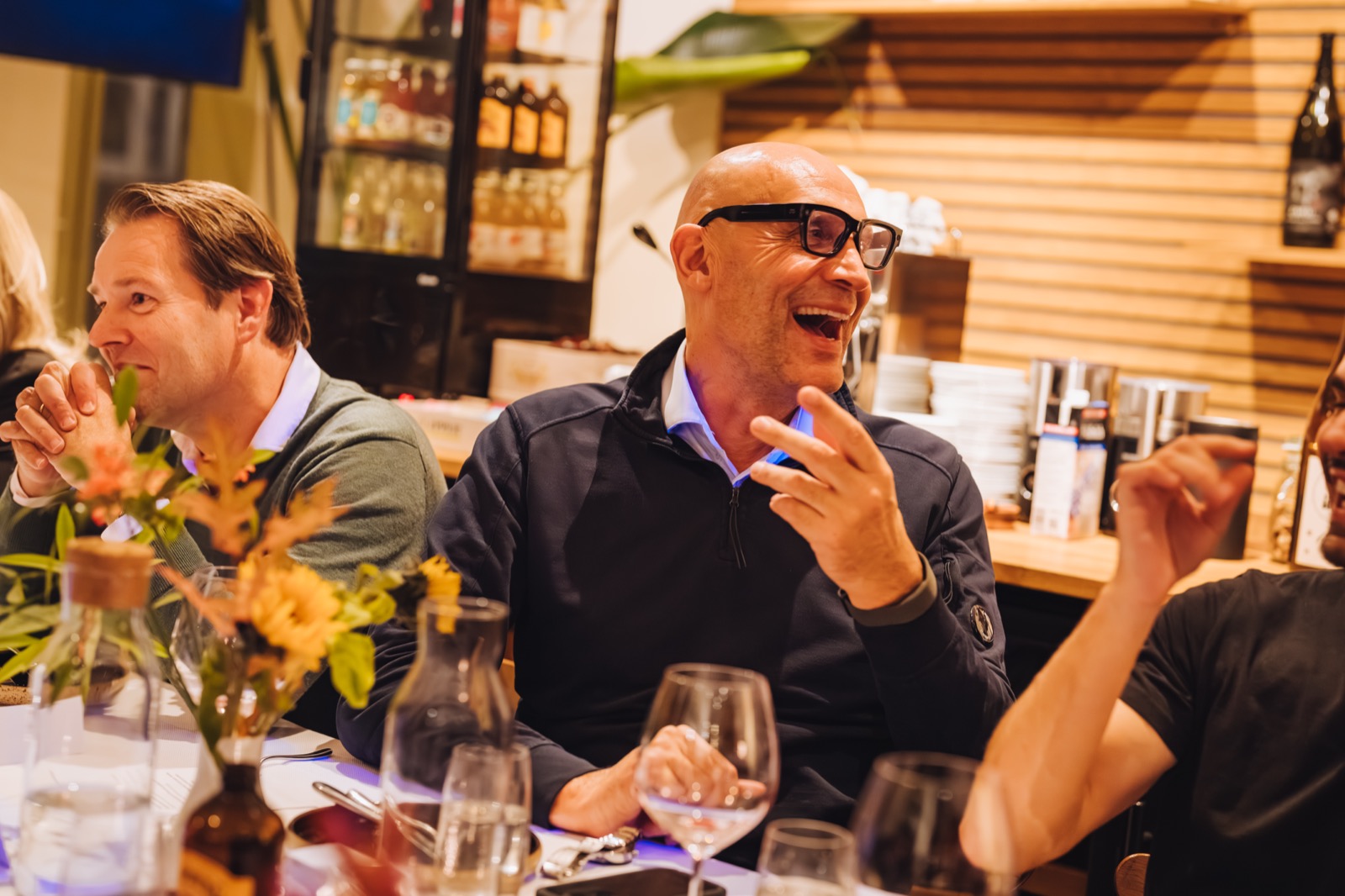 Gasten lachen aan tafel